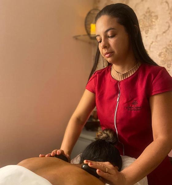 Massoterapeuta Liane fazendo massagem com pedras quentes